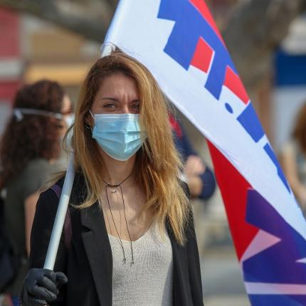 Μέλος του ΠΑΜΕ φορώντας μάσκα