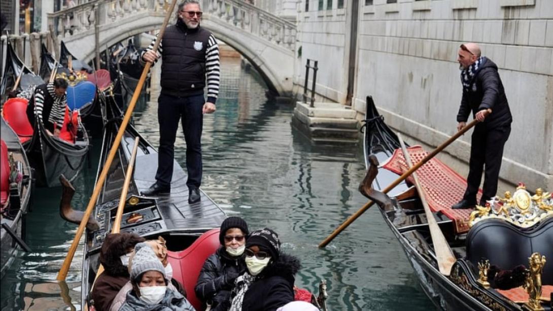 Τουρίστες με μάσκες, απολαμβάνουν τη βόλτα τους σε κανάλι της Βενετίας.