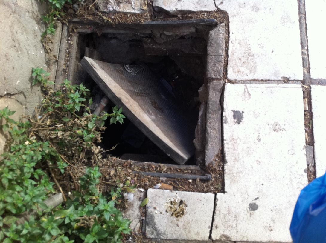  Το ακάλυπτο φρεάτιο στο στενό πεζοδρόμιο της μικρής Έβανς...